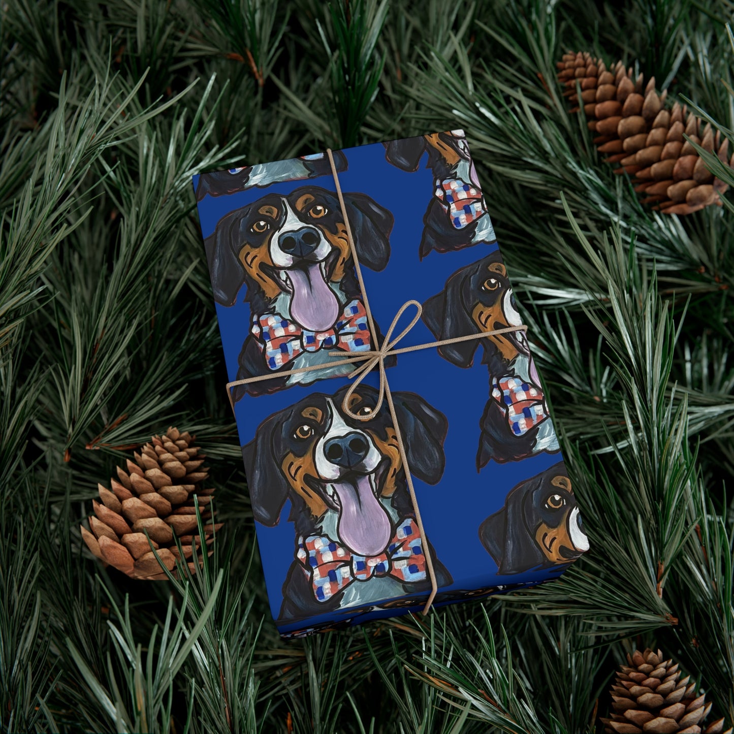 Gift box with dog-themed wrapping paper on a green leafy background