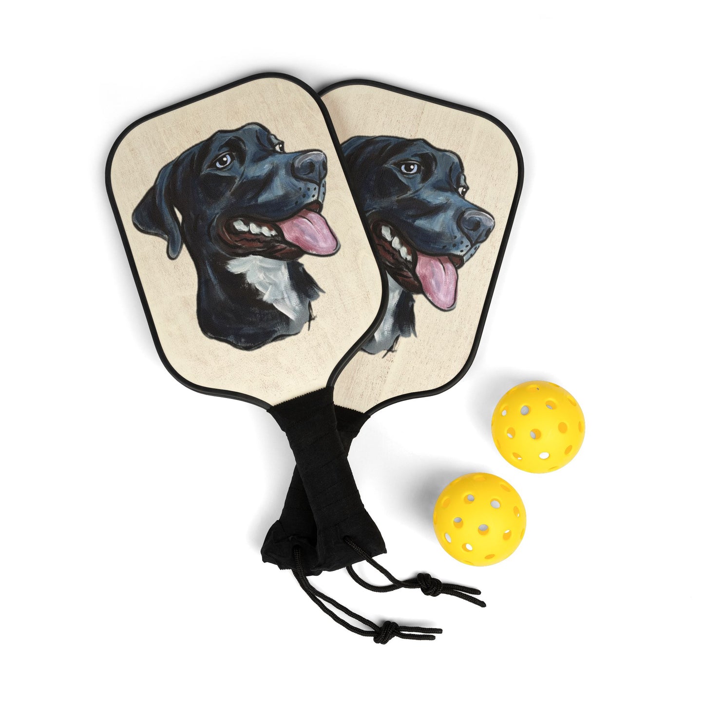 Pickleball paddles with a custom dog portrait design and three yellow balls on a white background
