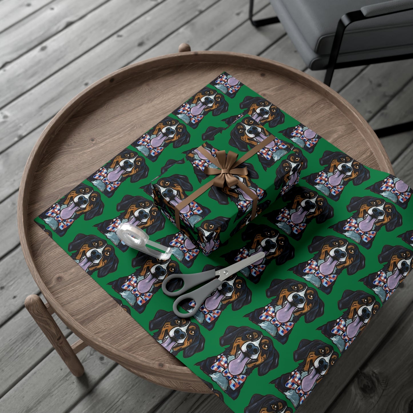 Gift boxes wrapped in green wrapping paper featuring custom hand drawn dog caricature portrait, scissors, and tape on a wood table