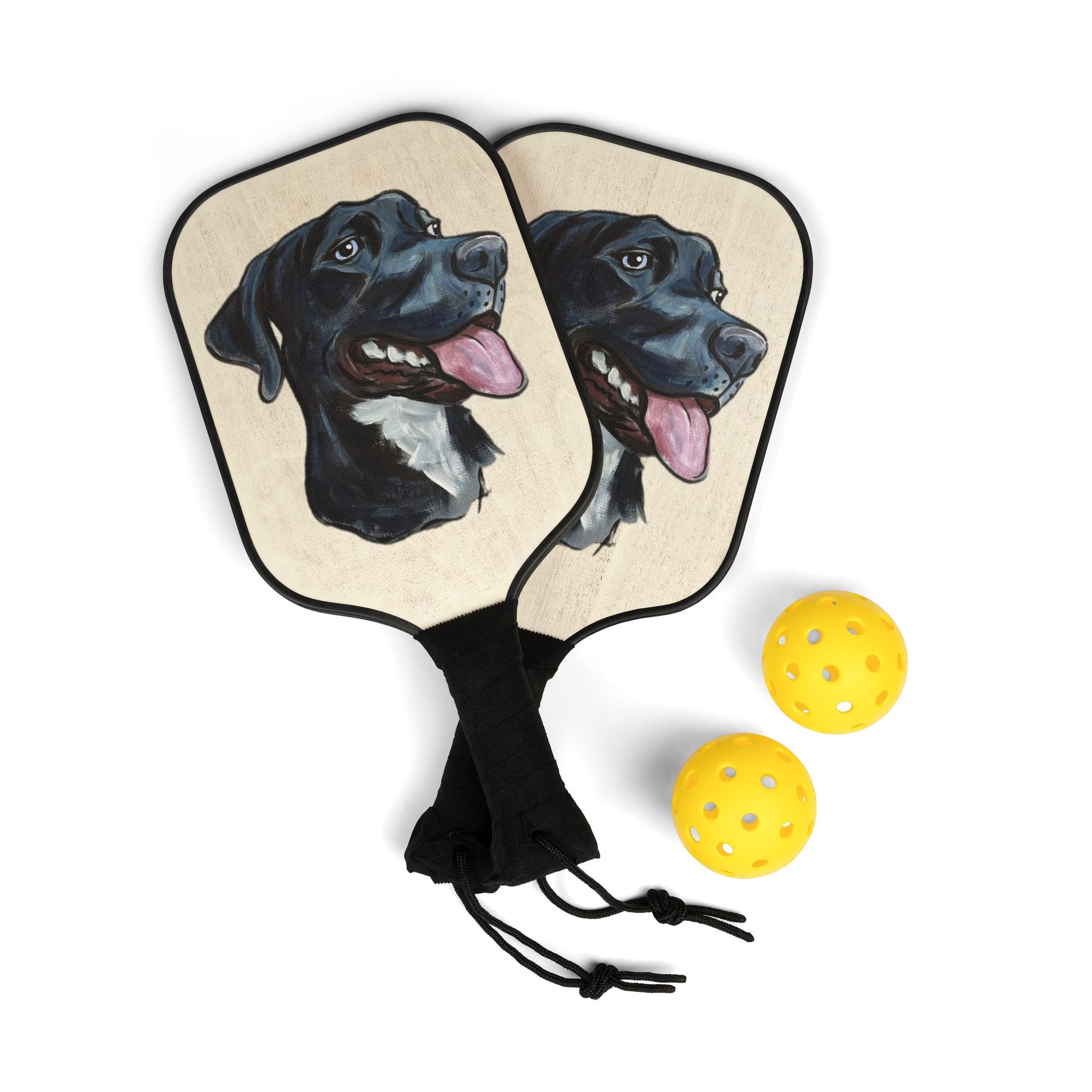 Pickleball paddles with a custom dog portrait design and three yellow balls on a white background