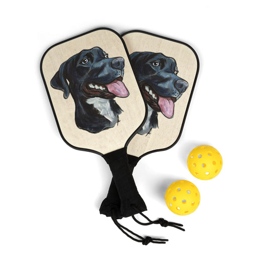 Pickleball paddles with a custom dog portrait design and three yellow balls on a white background